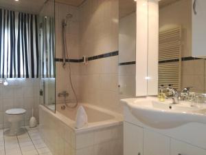 a bathroom with a sink and a tub and a toilet at Top Ferienwohnung Krämer in Koblenz