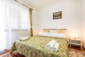 a bedroom with a large bed with towels on it at Apartment Muzic in Mali Lošinj