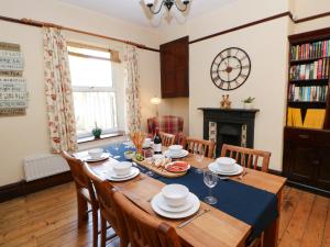 a dining room with a table with chairs and a fireplace at Langlands in Barnard Castle