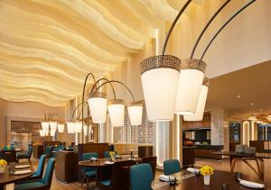 a restaurant with many chandeliers hanging from the ceiling at Taj Cidade de Goa Horizon, Goa in Panaji