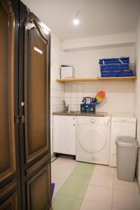 a small kitchen with a sink and a washing machine at Apartments villa Mira in Kaštela