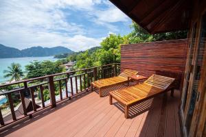 dos bancos sentados en una terraza con vistas al agua en Phi Phi The Beach Resort en Phi Phi Don