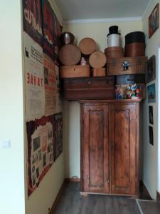 a room with a wooden cabinet and many pots and pans at Vilni Kimnaty in Mukacheve
