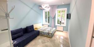 a blue living room with a couch and a window at Berta Maria in Odesa