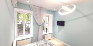 a room with blue walls and two windows and a bed at Berta Maria in Odesa