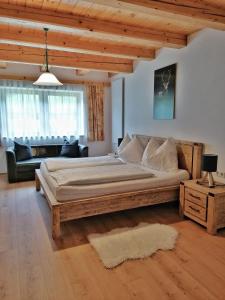 um quarto com uma cama grande e um sofá em Sonniges Landhaus in den Hohen Tauern em Rauris