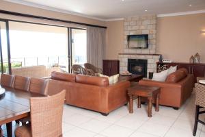 a living room with leather furniture and a fireplace at Cathkin Haven in Champagne Valley