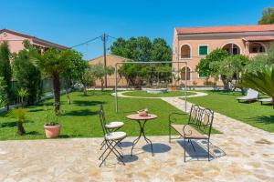 a patio with a table and chairs in a yard at La casa di Eleni in Acharavi