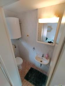 ein Badezimmer mit einem WC, einem Waschbecken und einem Spiegel in der Unterkunft Cool & Romantic Studio in Portoroz JB3 in Portorož