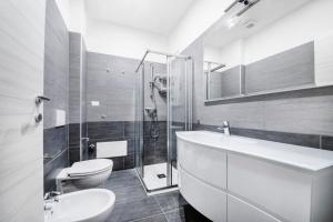 La salle de bains est pourvue de toilettes, d'un lavabo et d'une douche. dans l'établissement Como City Home, à Côme