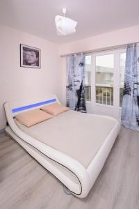 1 cama blanca grande en una habitación con ventana en Appartement 2 chambres Angers Centre de Congrès en Angers