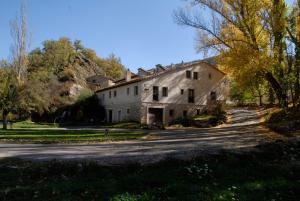 an old stone house with a road in front of it at Hospederia El Batan in Tramacastilla