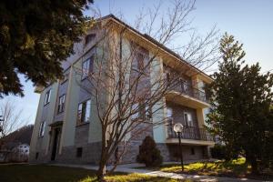 duży budynek z drzewem przed nim w obiekcie B&B Il castagno w mieście Roccavione
