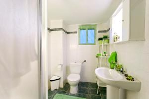 a white bathroom with a toilet and a sink at Gerakina Skala Holiday Houses in Gerakini