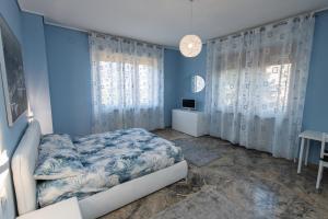 sypialnia z łóżkiem i niebieską ścianą w obiekcie B&B Il castagno w mieście Roccavione
