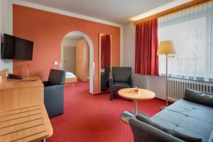 ein Hotelzimmer mit einem Sofa und einem Tisch in der Unterkunft Hotel Jägerhaus in Titisee-Neustadt