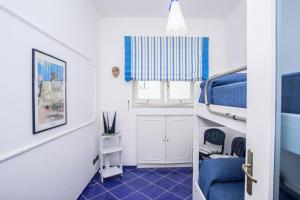 a small room with blue and white walls and a window at Villino Dei Gerani in Capri