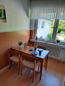 ein Esszimmer mit einem Tisch, Stühlen und einem Fenster in der Unterkunft Gästehaus Bleibergquelle in Velbert