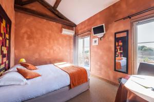 a bedroom with a bed and a large window at Logis hotels Les Glycines in Melle
