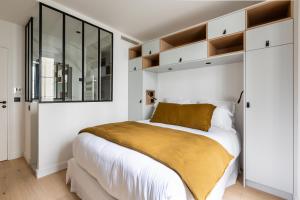 パリにあるPick A Flat's Apartment in Saint Germain - Rue Corneilleの白い壁のベッドルーム(大型ベッド1台、鏡付)