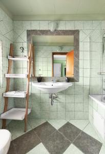 uma casa de banho com um lavatório e um espelho em Boryana Hotel em Burgas