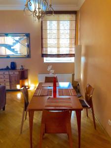 a dining room with a wooden table and chairs at Palasta Premium in Rīga