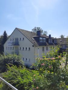 a large white house with a roof at Gästehaus Bleibergquelle in Velbert