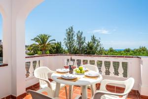 una mesa blanca y sillas en un balcón con vistas en Villa Olivera, en Son Bou