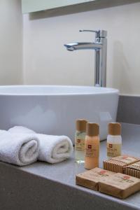 a bathroom counter with towels and products on it at Sol de Oro Hotel & Suites in Lima