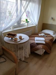 Una habitación con una cama con una mesa con comida. en Hotel Finezja en Świdnik