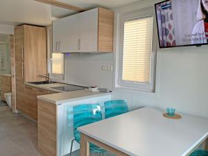 a kitchen with a white counter and blue chairs at Bonita HouseBoat Apartment Portorose in Portorož
