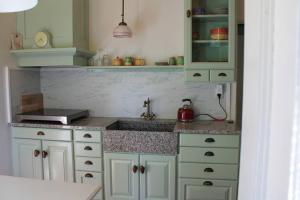 a kitchen with white cabinets and a sink at B&B Appartement De Winkeljuffer in Bakkeveen