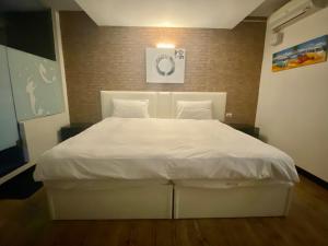 Postel nebo postele na pokoji v ubytování Love River Inn 愛河日央