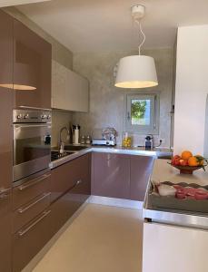 uma cozinha com electrodomésticos de aço inoxidável e uma taça de fruta em Residence Gli Oleandri 128 - Costa Smeralda - Porto Cervo em Porto Cervo