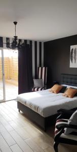 a bedroom with a large bed and a large window at Le cosy de sarah in Bordeaux-Saint-Clair