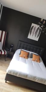 a bedroom with a white bed with a black wall at Le cosy de sarah in Bordeaux-Saint-Clair