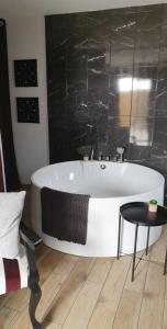 a bath tub in a bathroom with a table at Le cosy de sarah in Bordeaux-Saint-Clair
