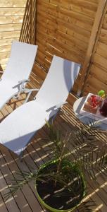two white umbrellas sitting on a deck with a plant at Le cosy de sarah in Bordeaux-Saint-Clair