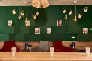 a restaurant with green walls and a table and chairs at Holiday Inn Express Amsterdam - City Hall, an IHG Hotel in Amsterdam