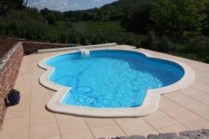- une piscine au milieu d'un patio dans l'établissement Chambres d'Hôtes La Roumec, à Escandolières