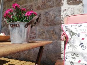 een emmer bloemen op een houten tafel bij Apartments Mas in Dovje