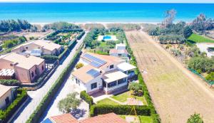een luchtzicht op een huis met de oceaan op de achtergrond bij Case Vacanze Mare Nostrum - Villas in front of the Beach with Pool in Campofelice di Roccella
