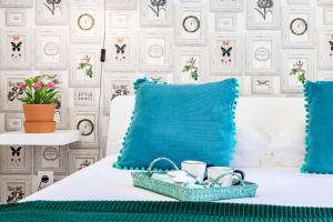 a bed with blue pillows and a tray of mugs at InLoveApartments - Alfama Best Balcony in Lisbon