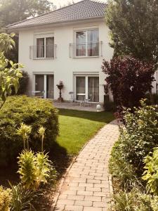 a house with a brick walkway in front of a yard at Pastel Guesthouse in Balatonfüred