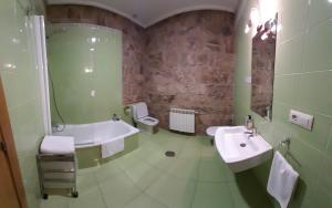 y baño con 2 lavabos, bañera y aseo. en Rectoral de Ansemil, en Ansemil