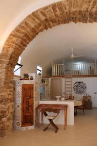 a kitchen with a table and a stone wall at Antico Granaio in Sciacca