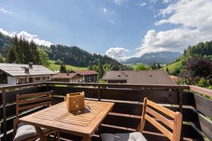 a wooden table on a balcony with a view of mountains at Oberstdorfer Bergwelt 108 in Oberstdorf