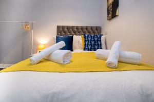 a bed with towels on a yellow blanket at Brunswick in Brighton and Hove by 9S Living in Brighton & Hove