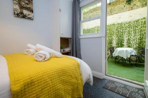 a bedroom with a yellow bed with towels on it at Brunswick in Brighton and Hove by 9S Living in Brighton & Hove