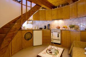 une cuisine avec des placards en bois et un escalier. dans l'établissement Traditional Windmill-Milos, à Kroústas